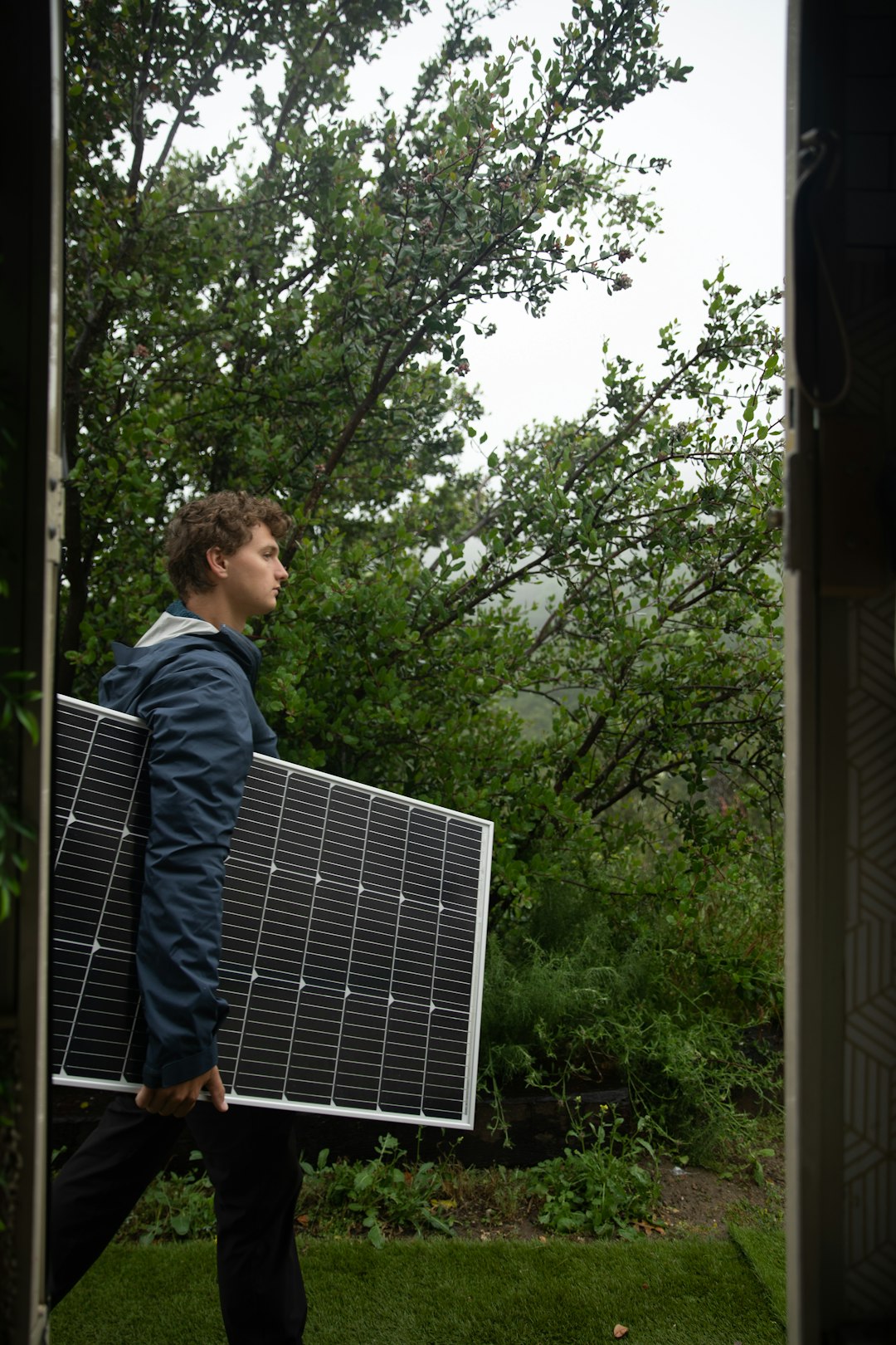 a-man-carrying-a-solar-panel-on-his-back-5d-ei2dgxy4